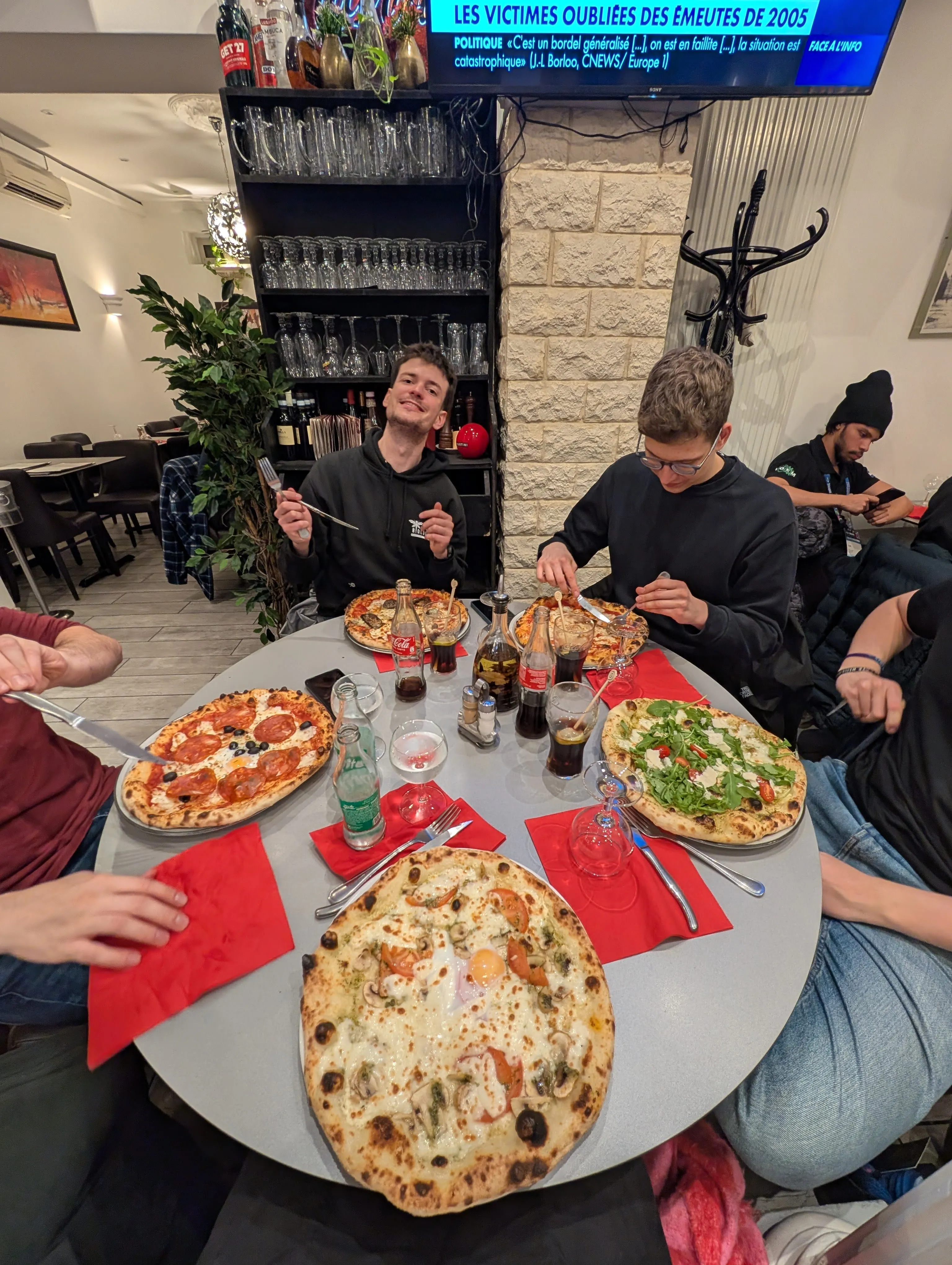 A table with plates of Pizza on it.