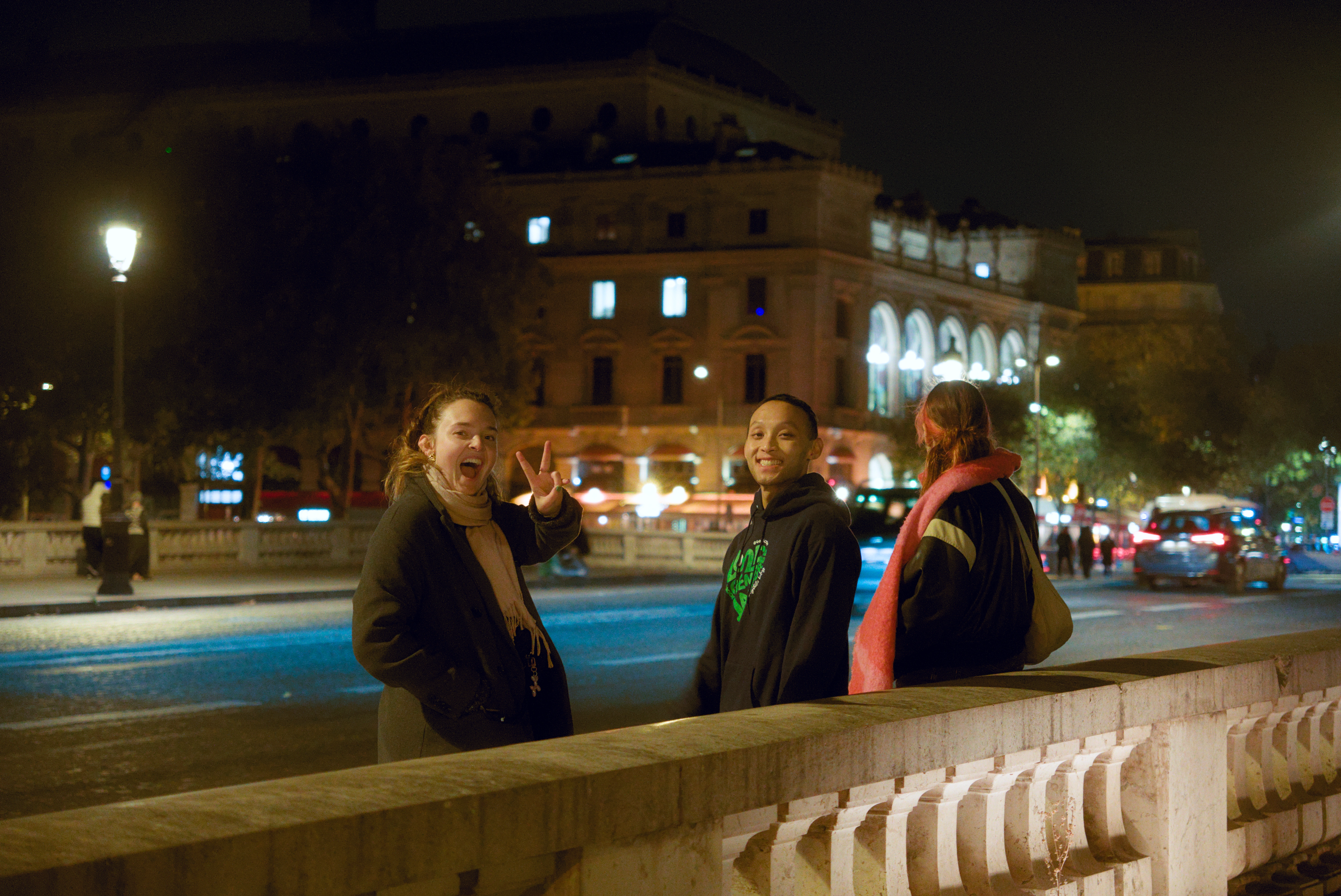 TRAPS members standing on a bridge in nightly Paris.