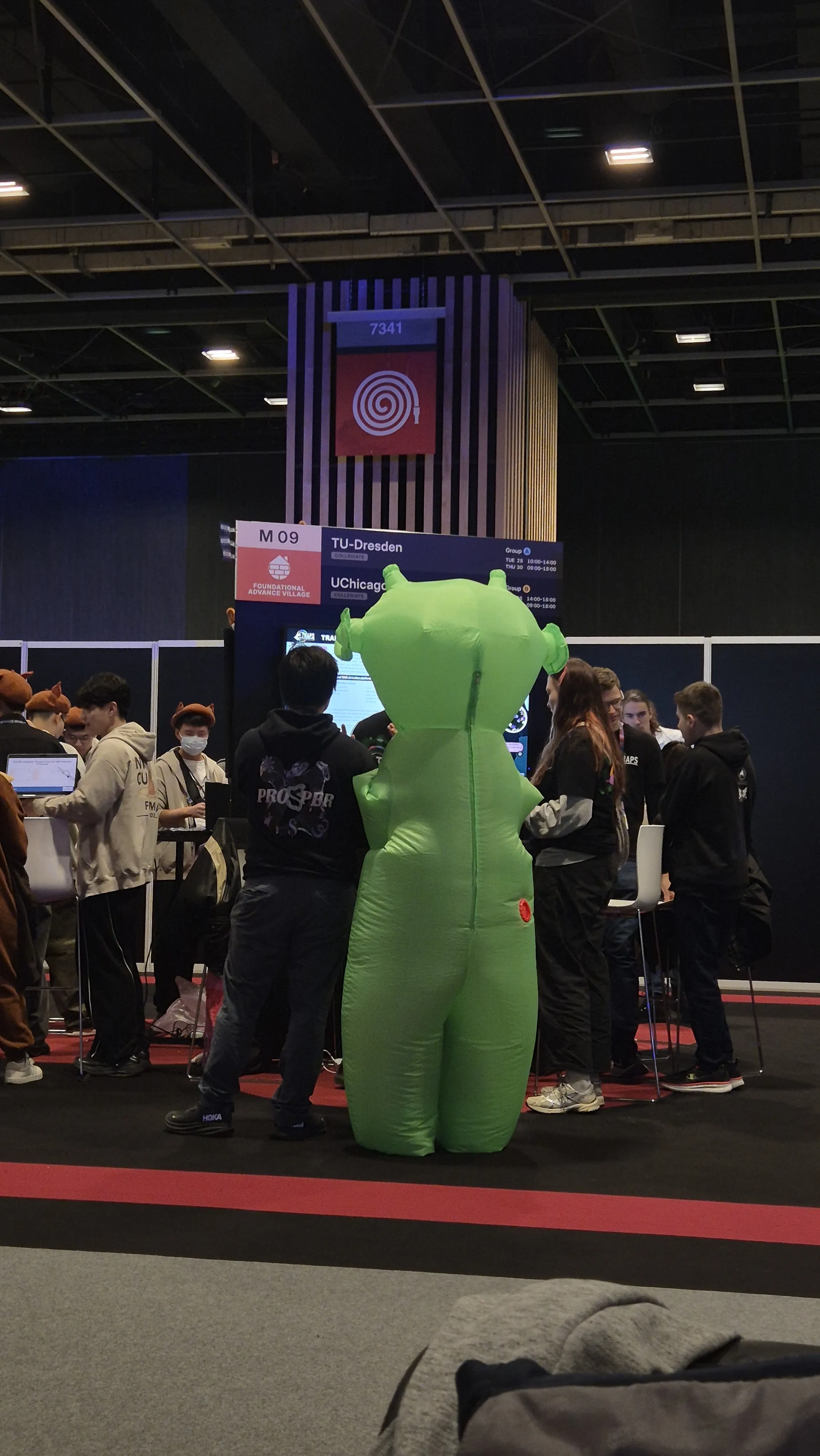 Someone in an alien costume visiting the TRAPS booth.