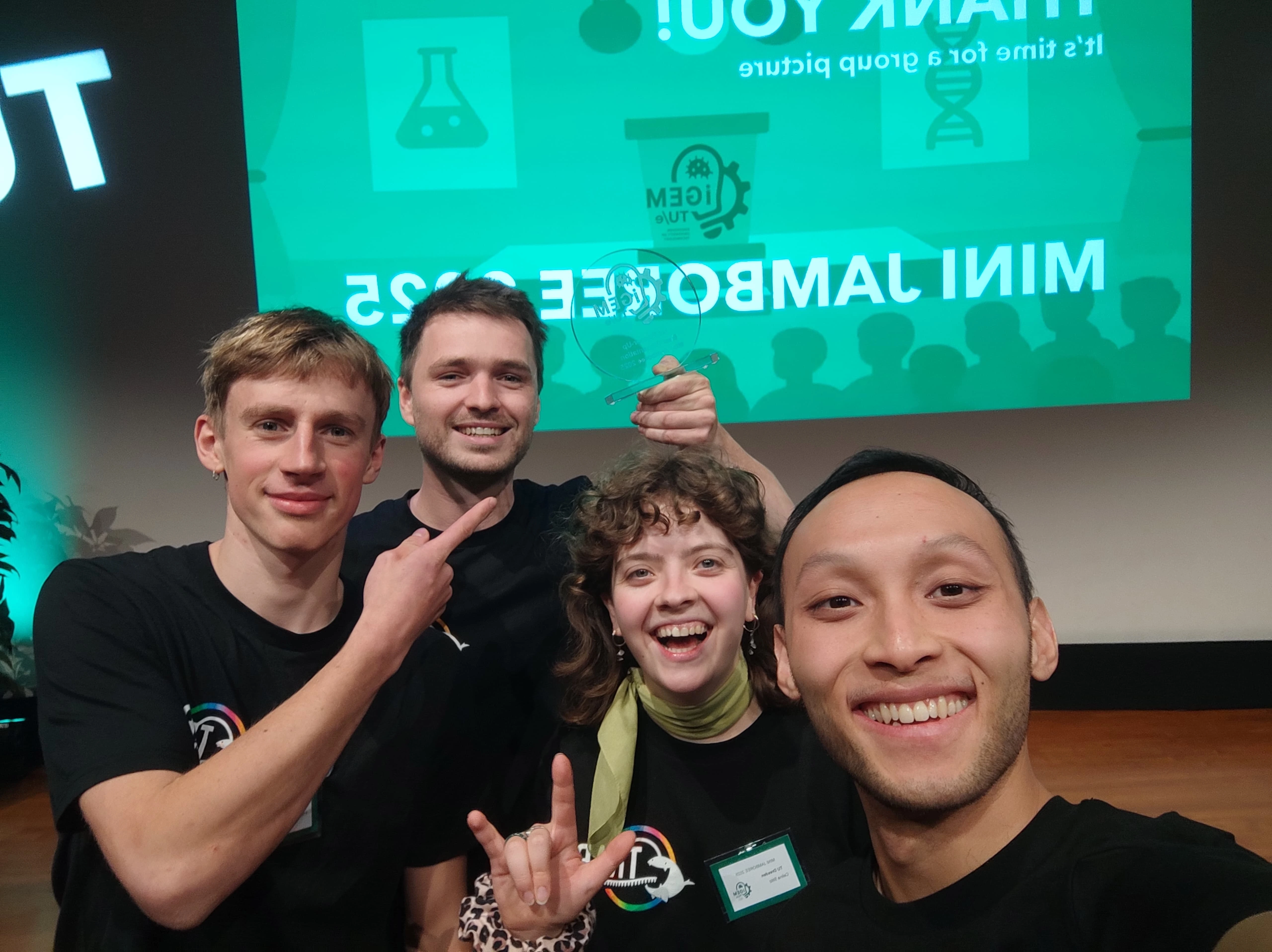Selfie of Celina, Lijing, Franz and Malte posing on a stage, with a price in their hand!